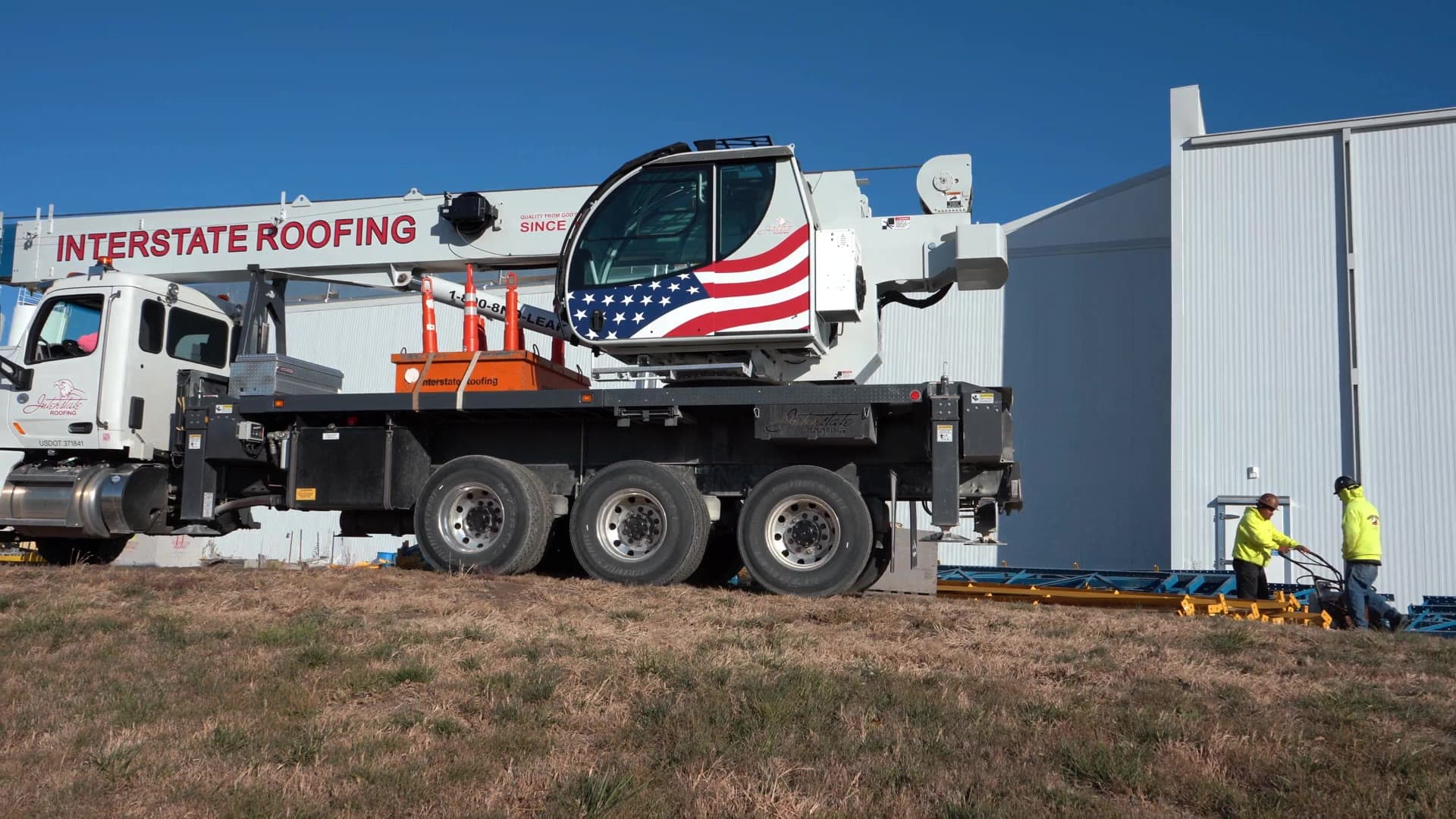 Interstate Roofing crane truck and crew on a commercial project site